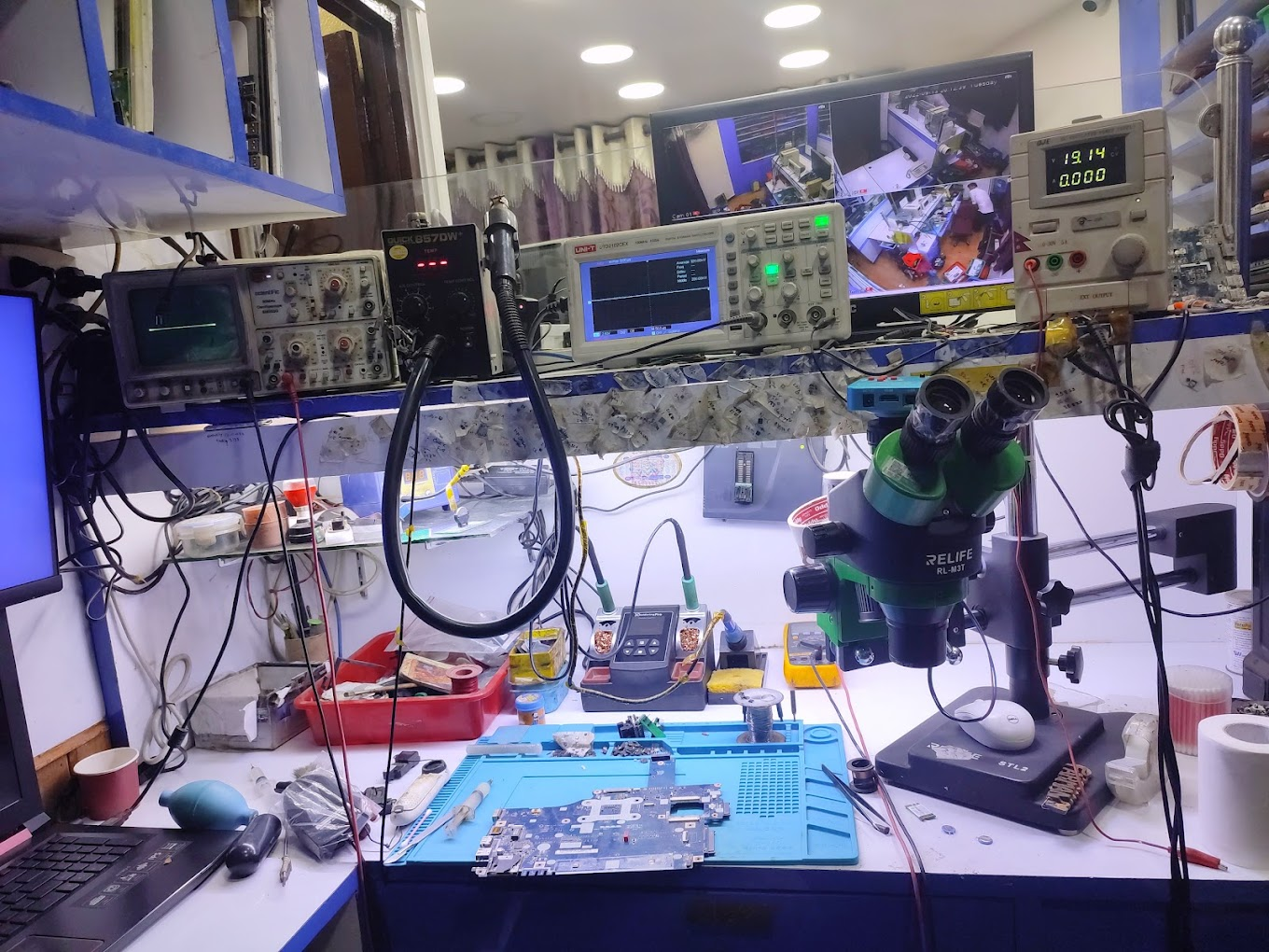 Repair workbench with oscilloscope, microscope, and soldering station